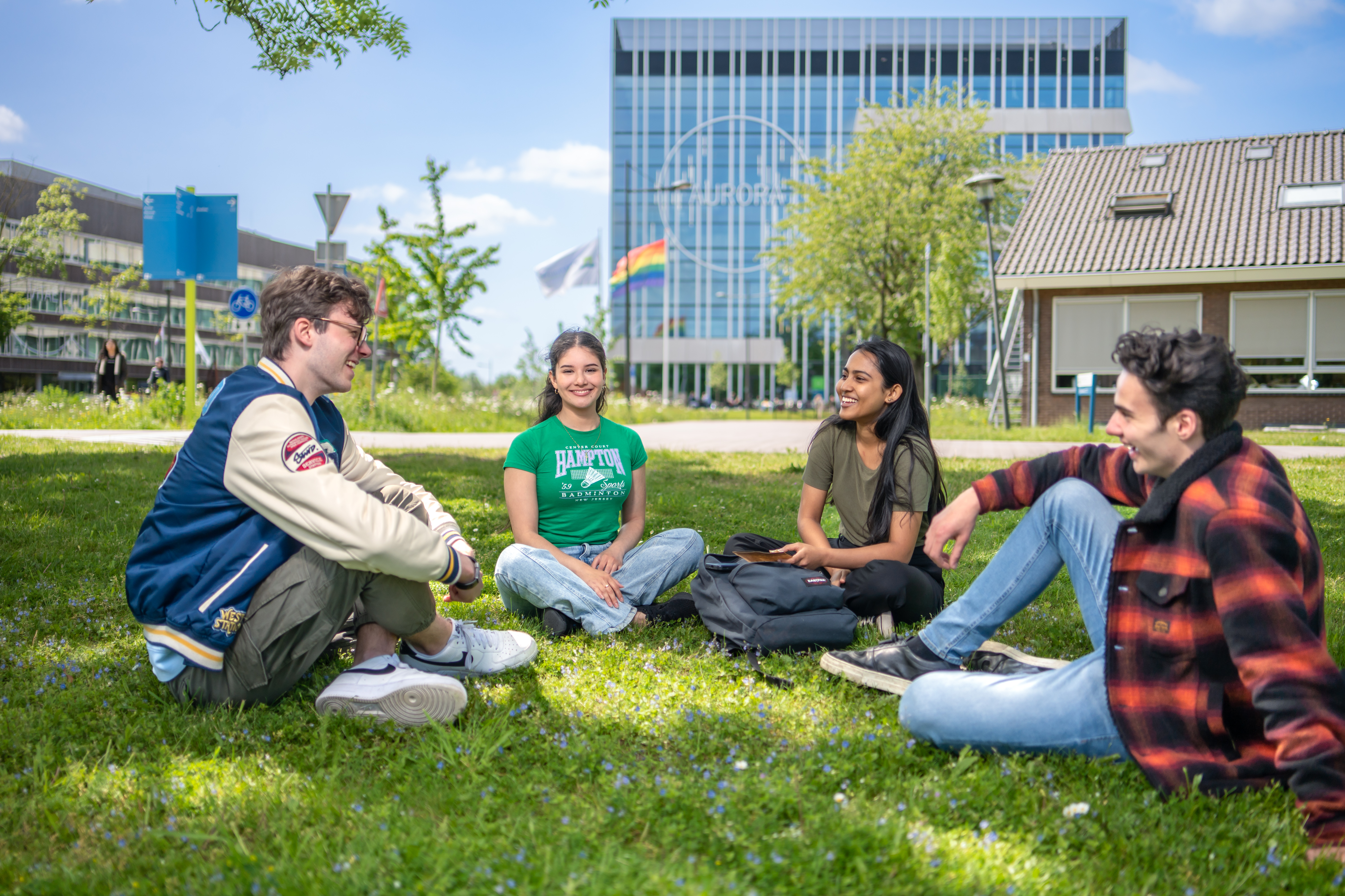 Fernanda, Bachelor Biotechnologie sitting on the grass in front of Aurora building with other students talking