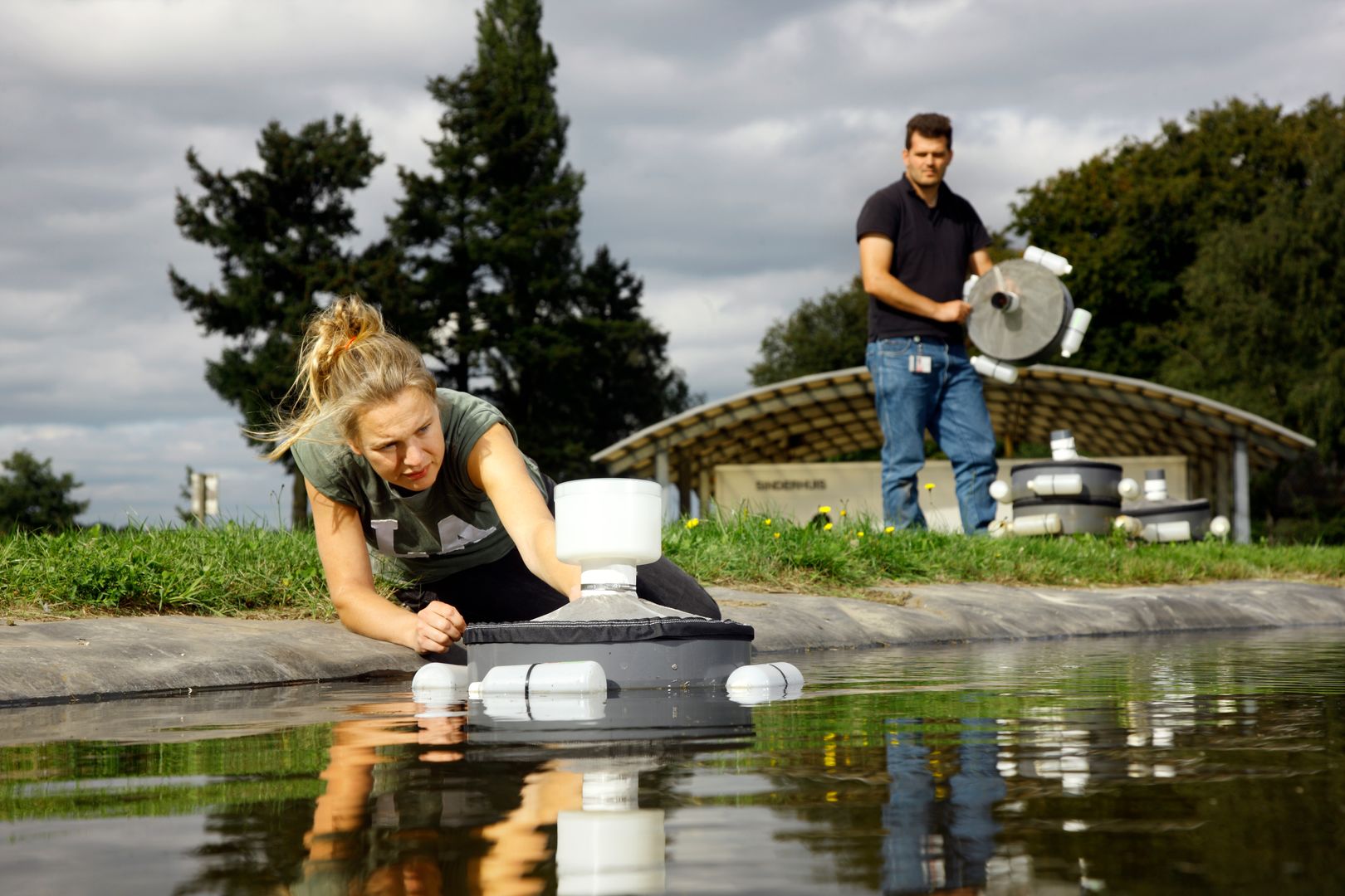 Een onderzoeker hanteert een wetenschappelijk apparaat op het water