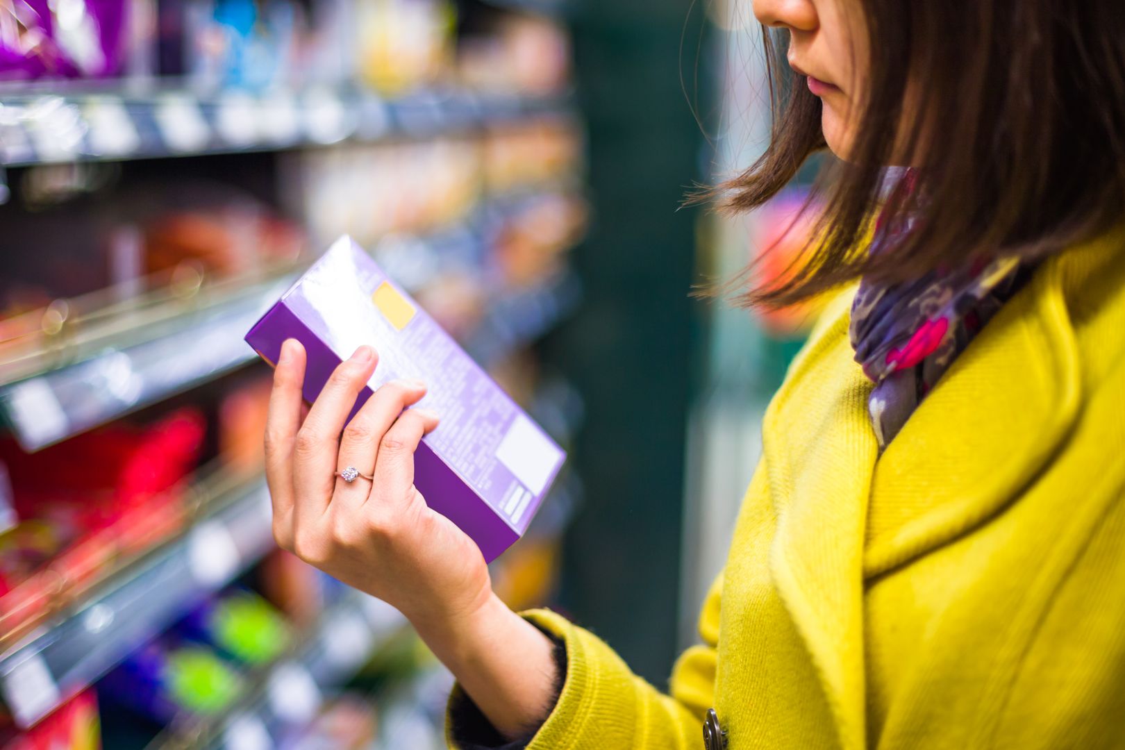 Girl reading food label in supermarket