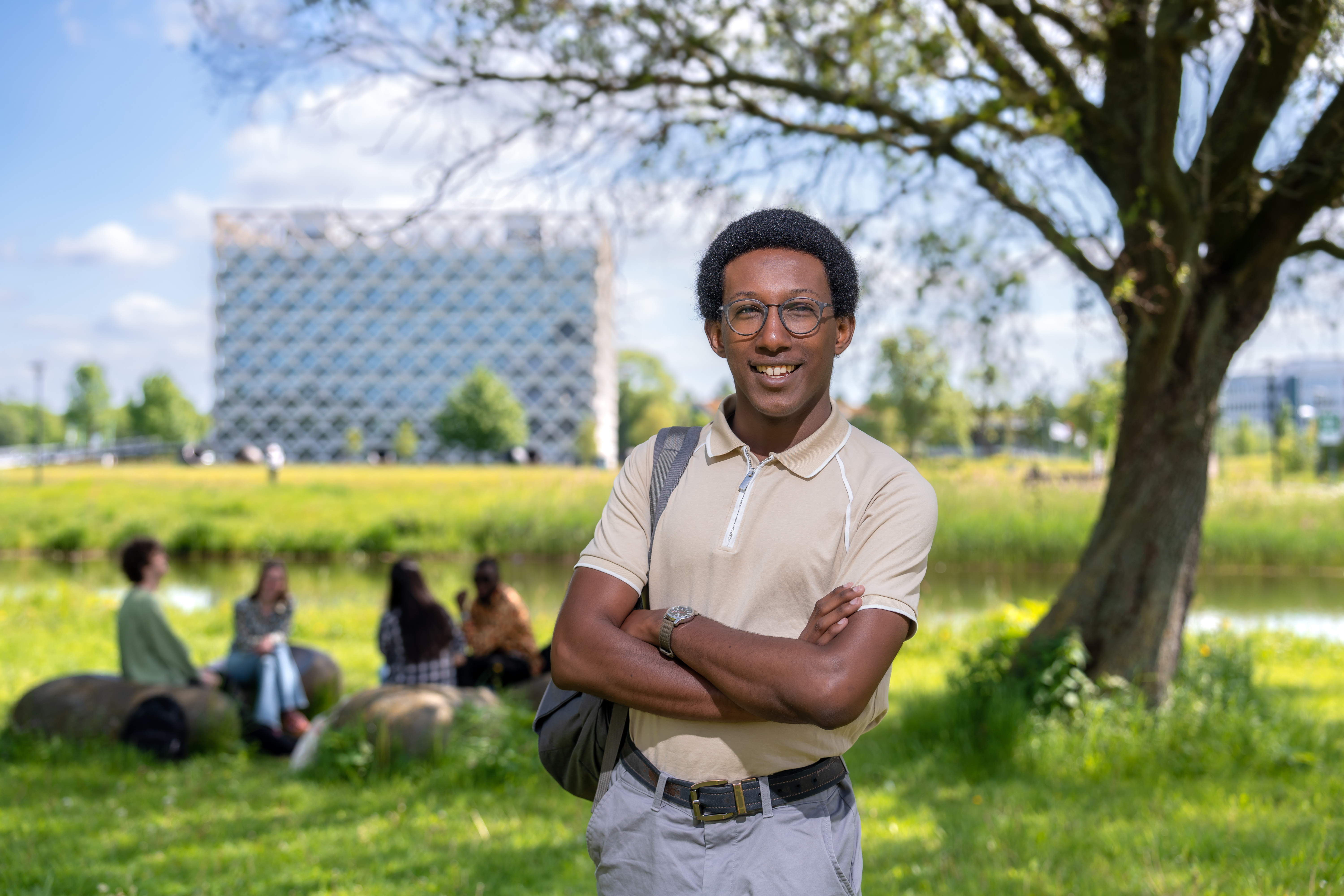 Quinlan, student Bachelor Bos- en Natuurbeheer posing on campus in front of the Atlas building near the lake