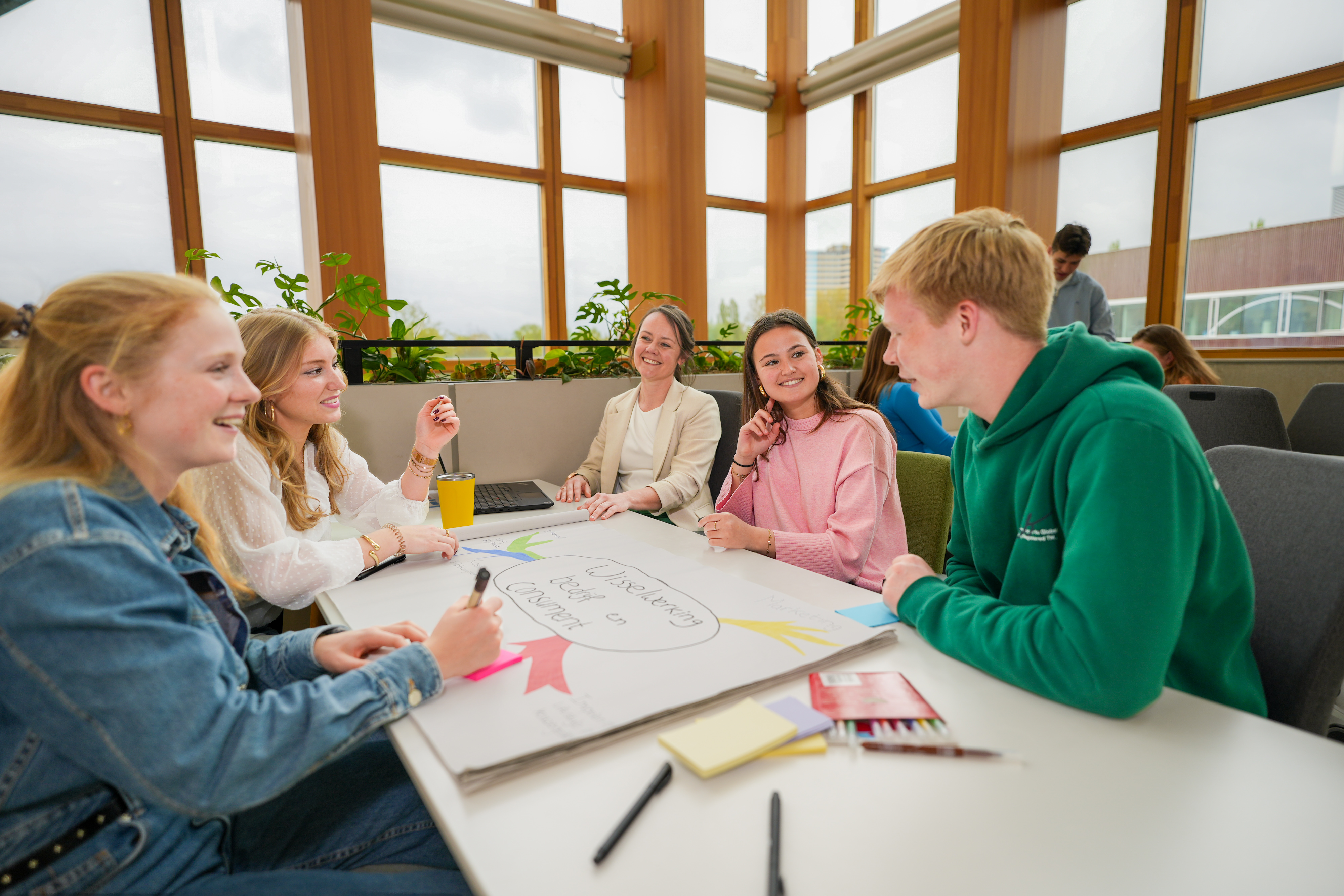 Bedrijfs en consumentwetenschappen studenten zitten om een tafel