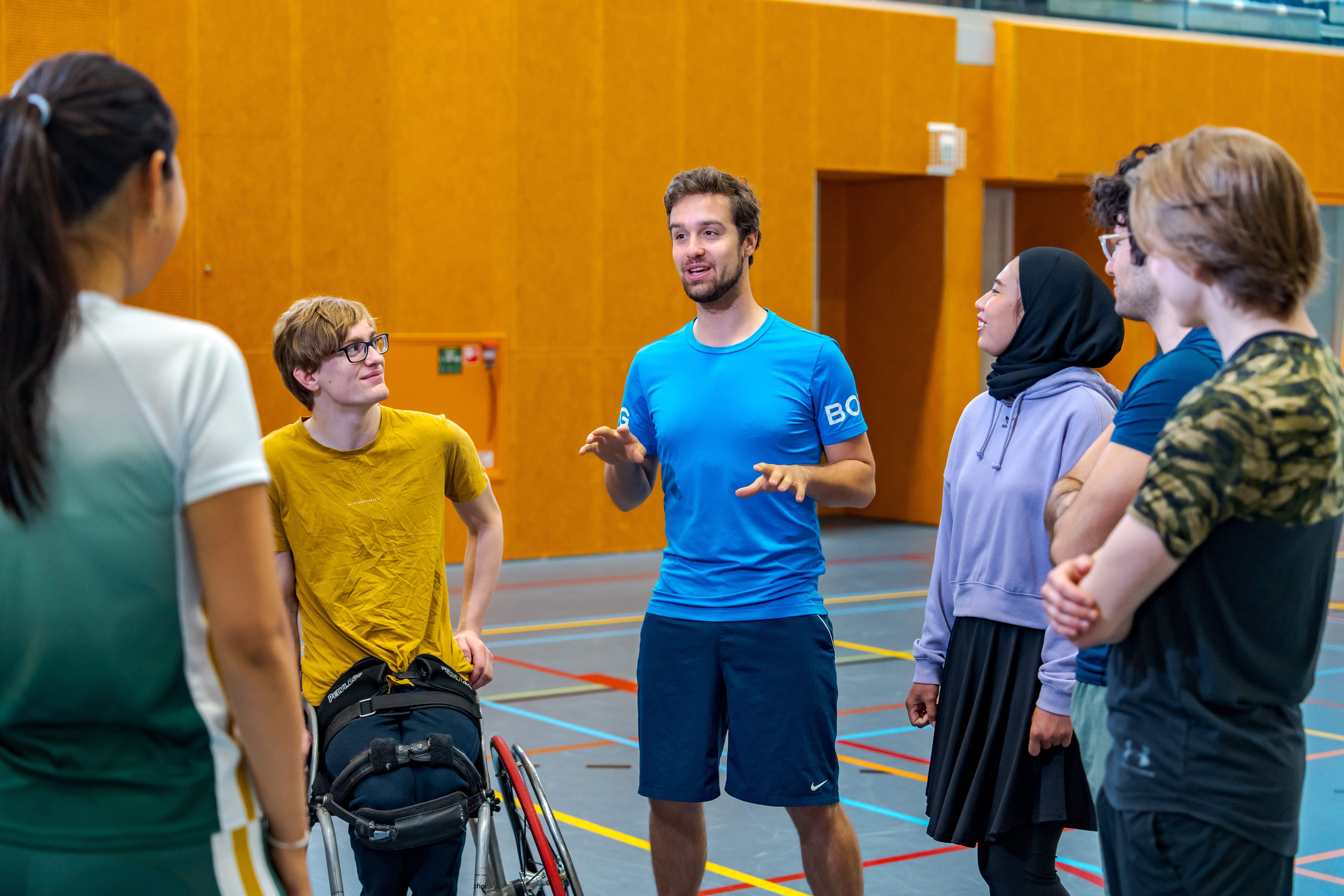 Sportleraar geeft uitleg in een sporthal
