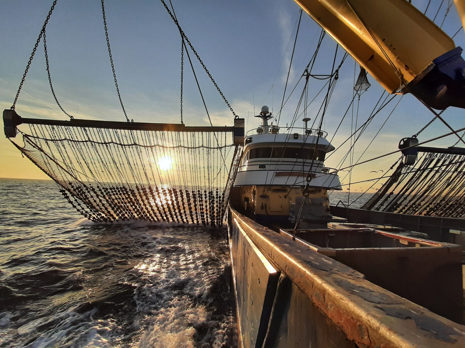A photo of a fishing boat during sunset