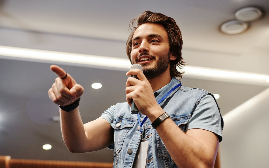 Man wijst naar publiek tijdens presentatie
