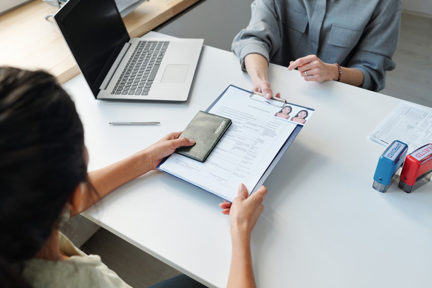 A person is submitting documents at a helpdesk