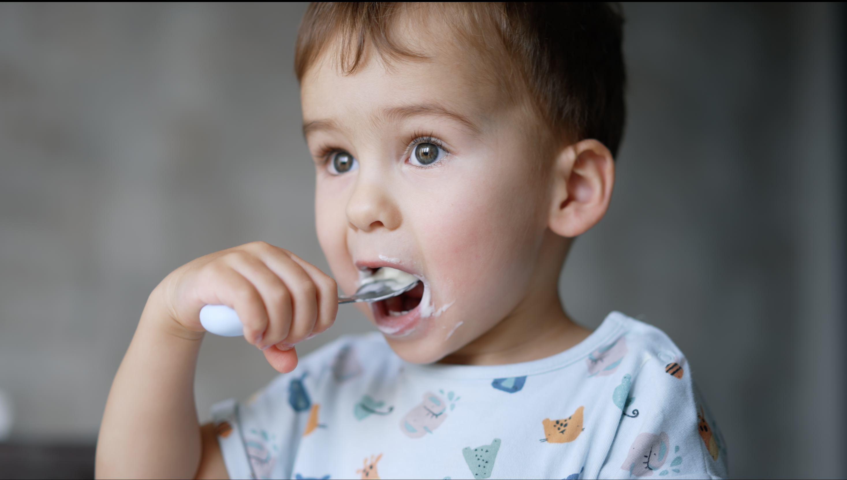 Jongetje eet joghurt met lepel