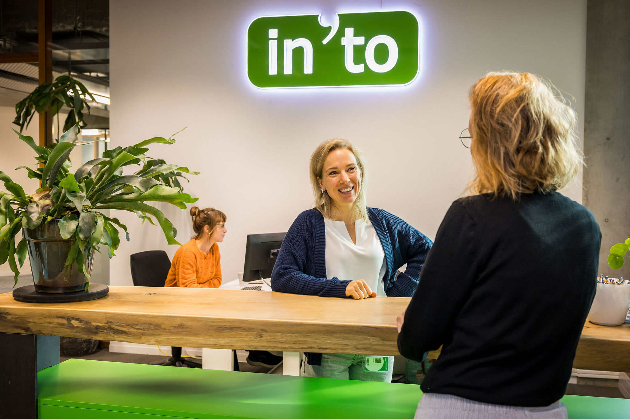 Medewerker In'to helpt klant aan de balie
