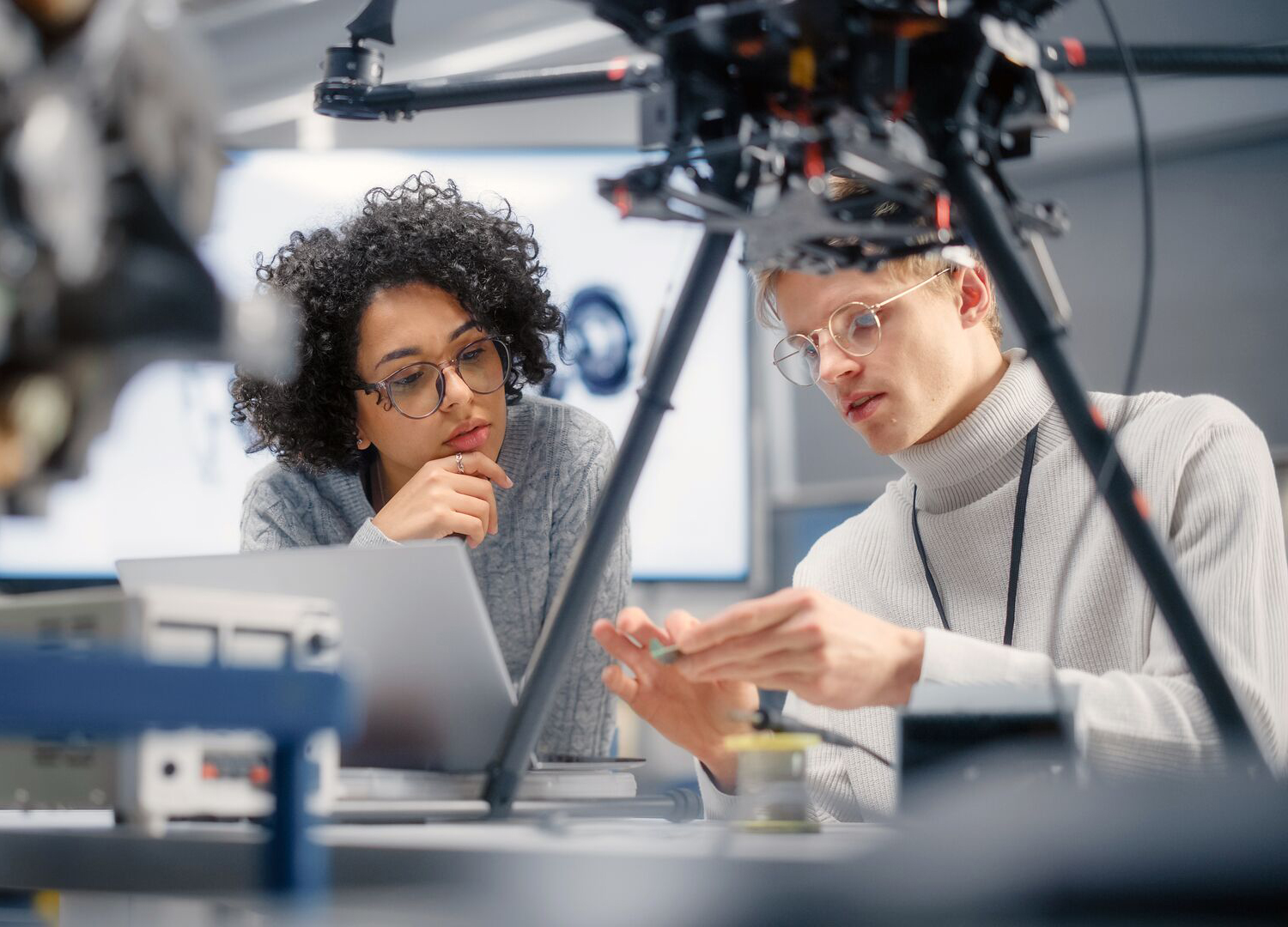 Twee studenten kijken naar een chip als onderdeel van een drone