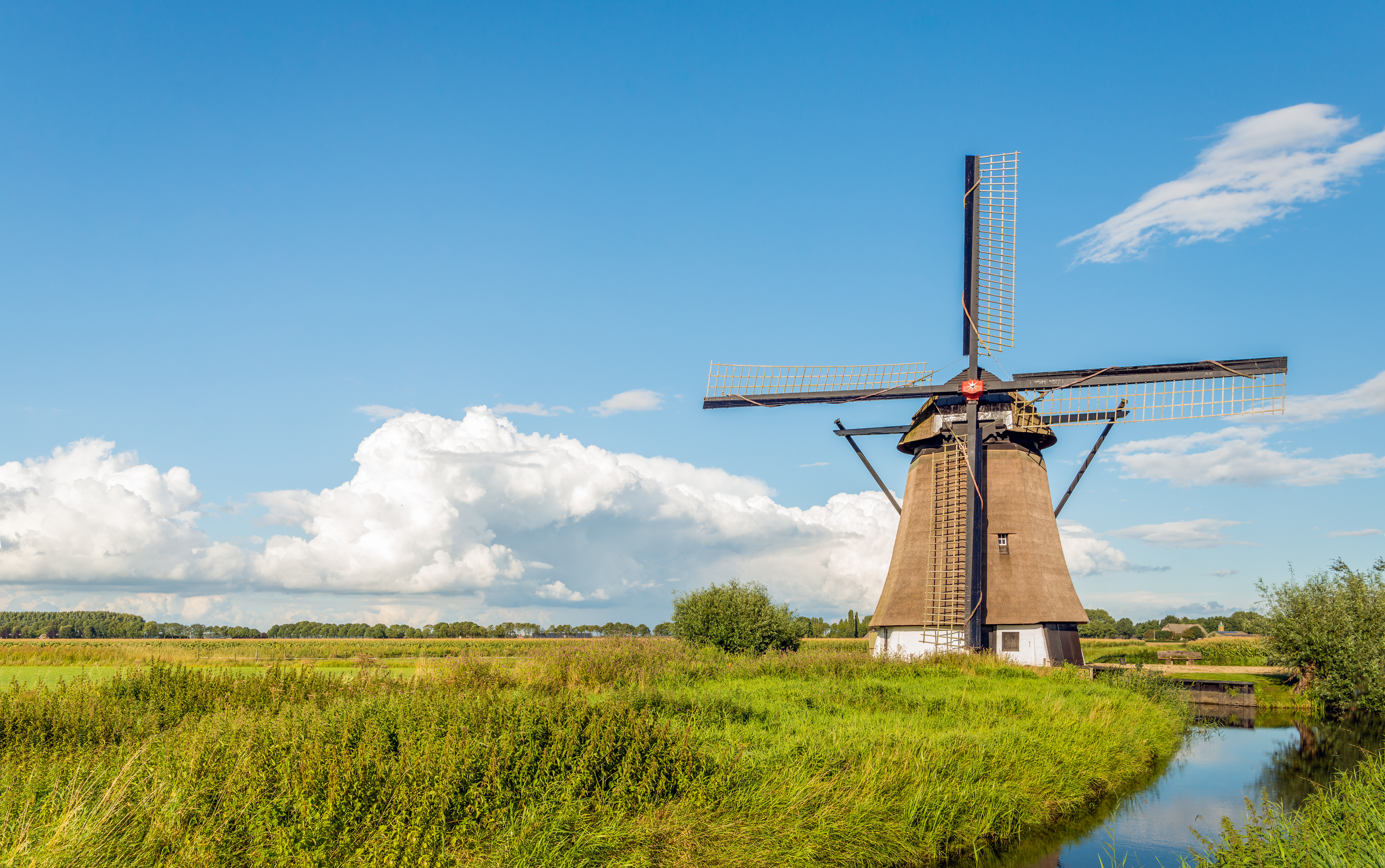 The eight-sided thatched windmill De Oude Doorn near the Dutch village of Almkerk was built around 1700 and restored in 2012. It is a sunny day in the late summer season.
