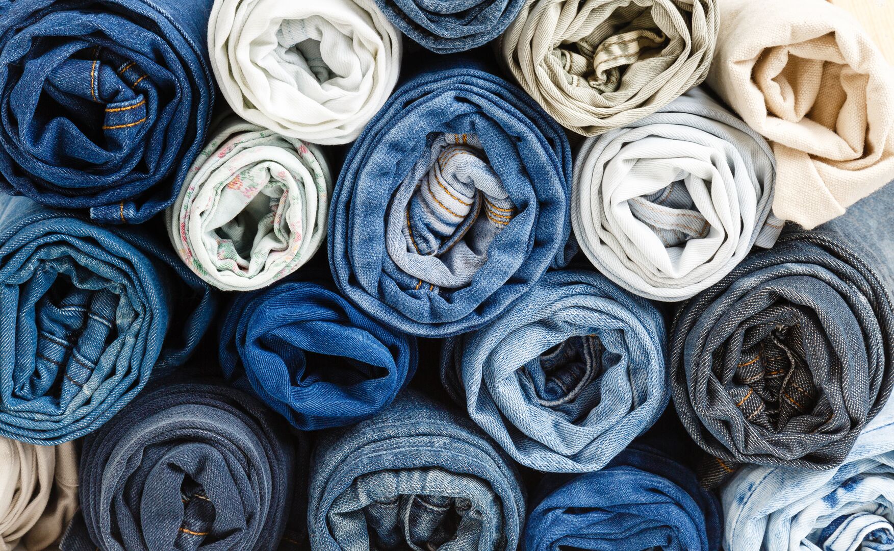 A picture of a pile rolled up jeans from aside