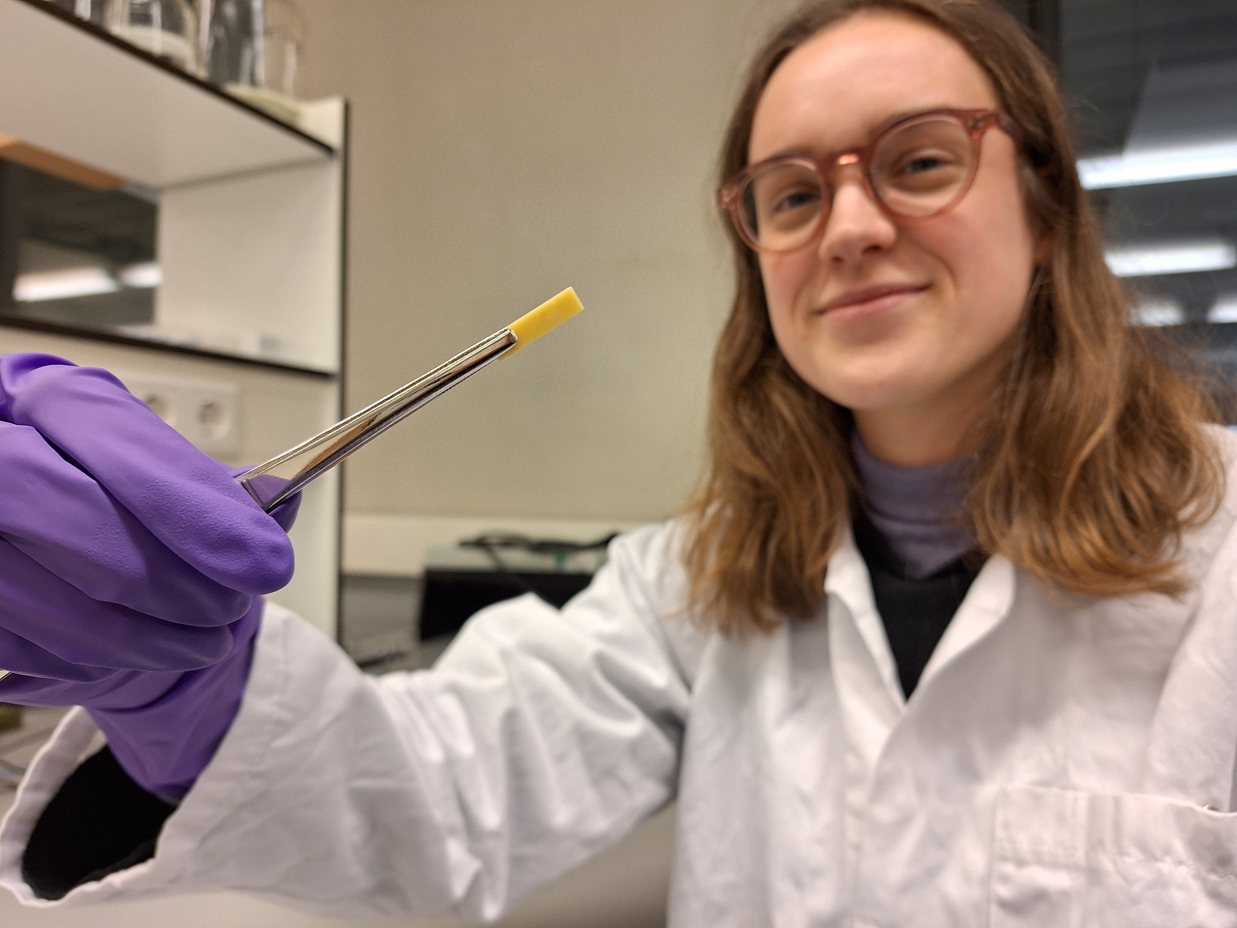 Onderzoekster houdt een stukje compleximeer vast met een pipet