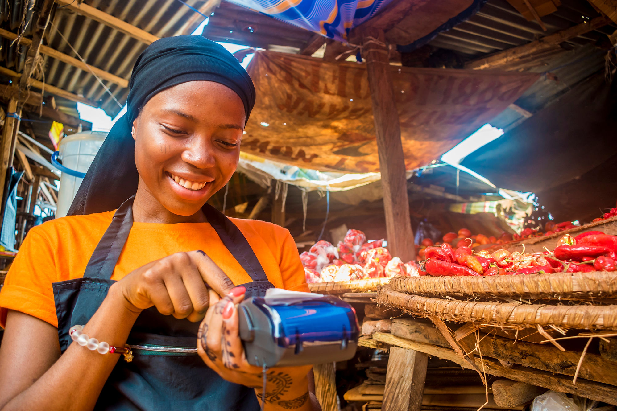 Nigerian woman putting in price of wares in card machine.