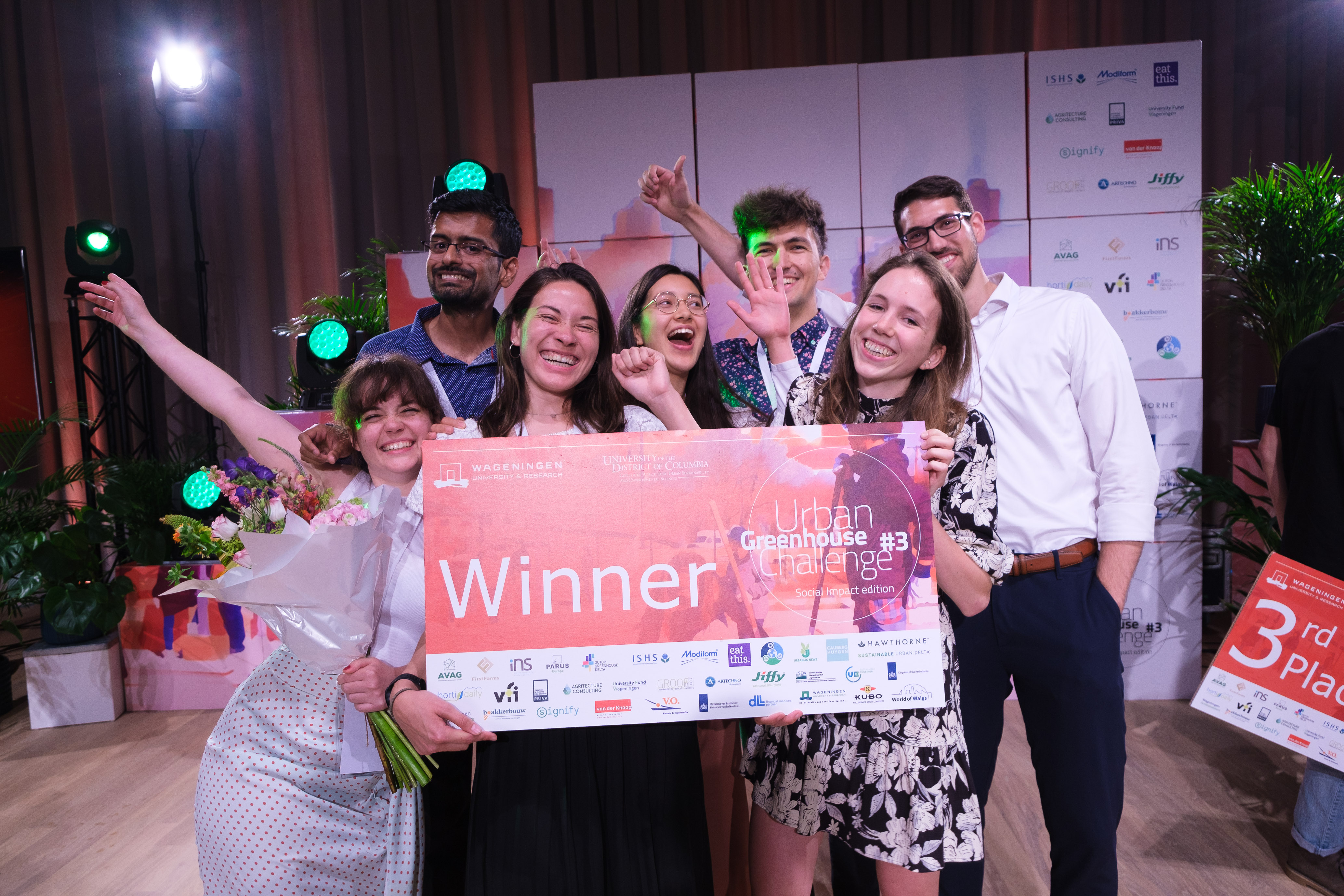 A group of students holding a cheque that says 'winner' of the student challenge