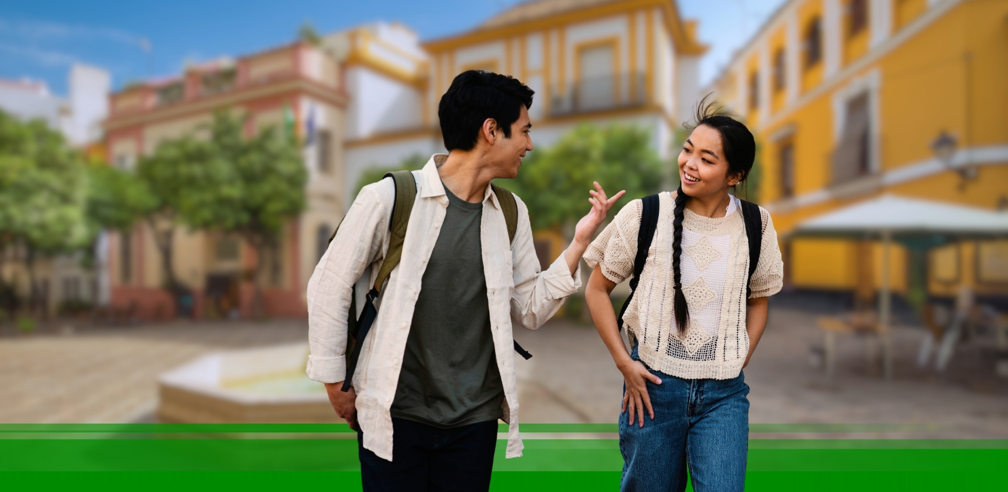 Two young people talking with a Spanish city in the background