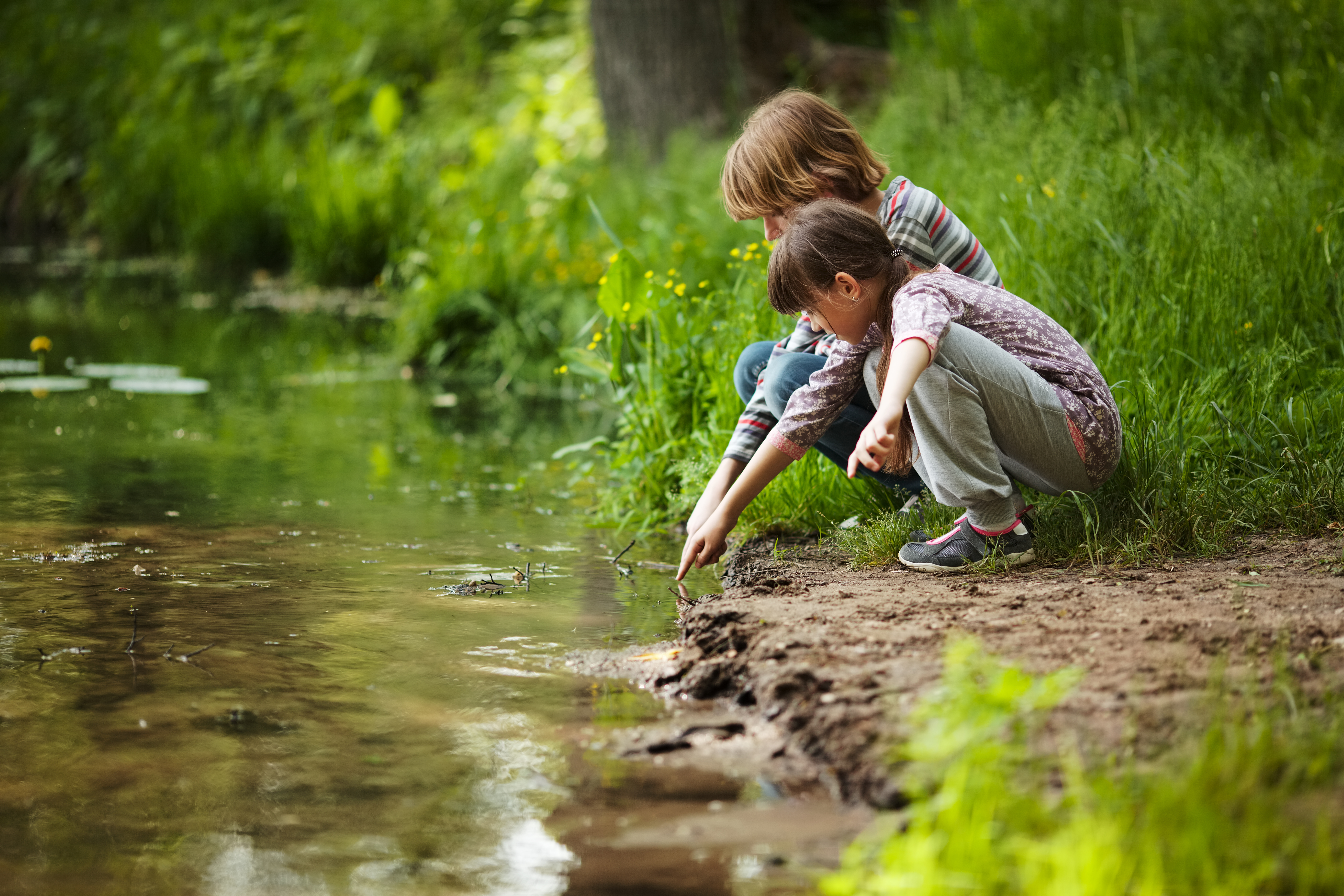 Boy with a girl sitting near the water
