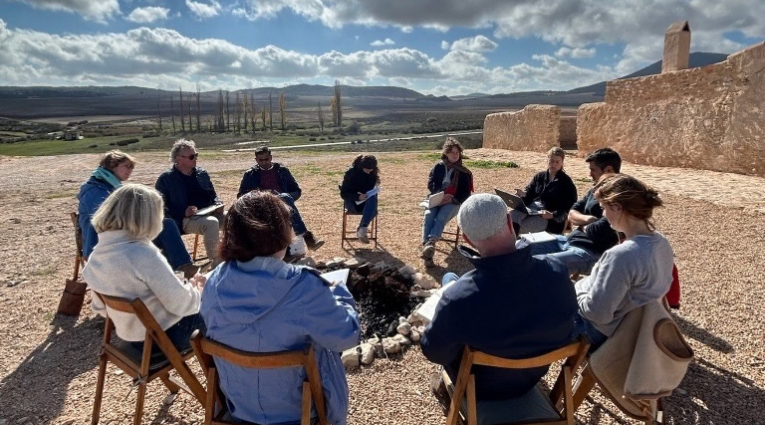 group sitting in circle in dry landscape