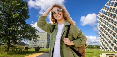 Vrouw met zonnebril en rugzak op WUR campus