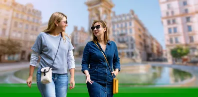 Two woman talking while walking through a city in France