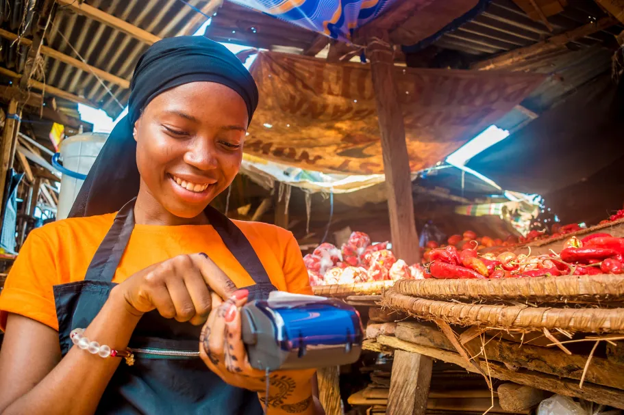 Nigerian woman putting in price of wares in card machine.