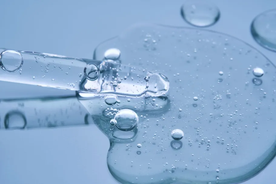 Pipette with transparent gel on a blue background