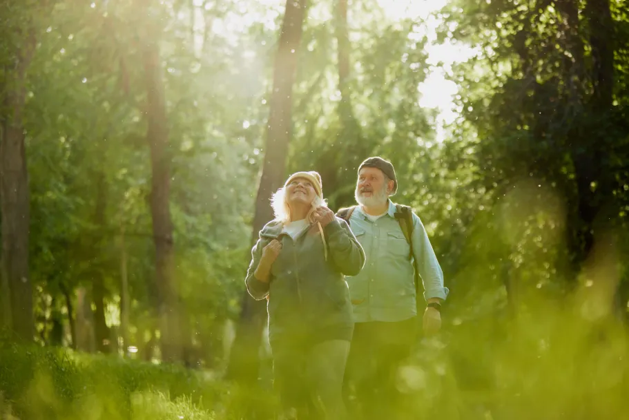 Senior couple man woman taking walk in park