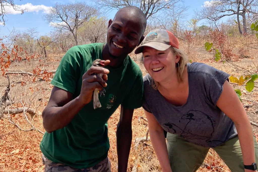 Honey-hunter Mele and Jessica posing with a honeyguide. 