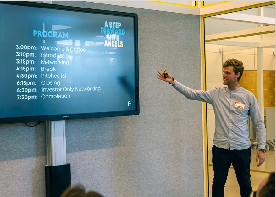 Tom Kloosterman presents a slide with a program for an event