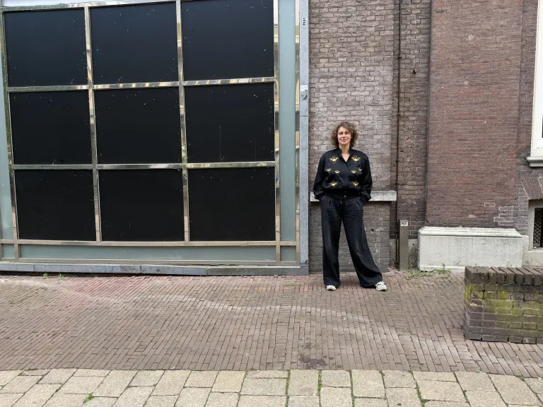 Woman with curly hair in front of brick wall