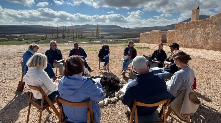 group sitting in circle in dry landscape