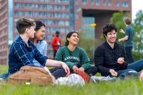 Studenten zitten in het gras op de campus